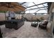 Cozy screened patio features a stone fireplace, hot tub, a koi pond, and an outdoor seating area at 664 Mission Hills Trl, The Villages, FL 32162