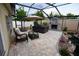 Relaxing screened patio with stone fireplace, a hot tub, koi pond, and outdoor seating area at 664 Mission Hills Trl, The Villages, FL 32162