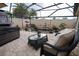 Relaxing screened patio with a koi pond, seating area, and stone fireplace at 664 Mission Hills Trl, The Villages, FL 32162
