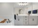Bathroom with double sink vanity, large mirror, and separate tub with a wooden bath tray at 678 Blackstone St, Minneola, FL 34715