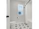 Bright bathroom featuring star patterned floor tiles, white fixtures, and a window providing natural light at 678 Blackstone St, Minneola, FL 34715