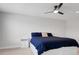 Minimalist bedroom with a bed, ceiling fan, and neutral color scheme at 678 Blackstone St, Minneola, FL 34715