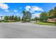 A picturesque intersection and entrance to the Asummo community with mature trees at 678 Blackstone St, Minneola, FL 34715