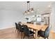 Dining area features modern lighting, wood table with seating for six, and hardwood floors at 678 Blackstone St, Minneola, FL 34715