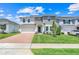 Beautiful two-story home with manicured lawn, brick driveway, and welcoming front entrance at 678 Blackstone St, Minneola, FL 34715