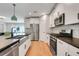 Modern kitchen with a farmhouse sink, stainless steel appliances, and breakfast bar at 678 Blackstone St, Minneola, FL 34715