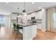 Modern kitchen with island, white cabinetry, stainless appliances, and hardwood flooring at 678 Blackstone St, Minneola, FL 34715
