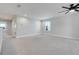 Spacious living room featuring neutral carpet, a ceiling fan, and abundant natural light from a window at 678 Blackstone St, Minneola, FL 34715