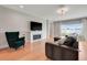 Open-concept living area with fireplace, lots of natural light, and hardwood floors at 678 Blackstone St, Minneola, FL 34715