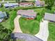Aerial view of the property showcasing its spacious lawn, landscaping, and extended driveway at 71 Stone Haven Ct, Leesburg, FL 34788