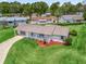 Property featuring a well-maintained lawn, mature landscaping, and extended driveway at 71 Stone Haven Ct, Leesburg, FL 34788