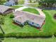 Aerial view of the property showcasing the lush green lawn, mature landscaping, and home's architecture at 71 Stone Haven Ct, Leesburg, FL 34788