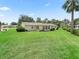 Extensive green backyard with healthy lawn, shrubbery, and view of the home's exterior at 71 Stone Haven Ct, Leesburg, FL 34788