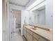 Well-lit bathroom with a large mirror, vanity, and a separate shower and toilet area at 71 Stone Haven Ct, Leesburg, FL 34788