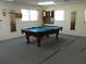 Recreation room features a billiard table with cues and wall decor at 71 Stone Haven Ct, Leesburg, FL 34788