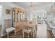 Cozy dining area with a wooden table, chairs, and a glass-front cabinet, bathed in natural light from the adjacent living space at 71 Stone Haven Ct, Leesburg, FL 34788