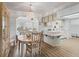 Bright dining area featuring a wood table set with a decorative light fixture and an adjacent, open kitchen space at 71 Stone Haven Ct, Leesburg, FL 34788