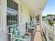 A covered front porch with a sitting area is adorned with flowers and features bright, natural light at 71 Stone Haven Ct, Leesburg, FL 34788