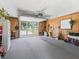 Spacious garage with wood paneling, carpeted floor, and an open garage door allowing natural light at 71 Stone Haven Ct, Leesburg, FL 34788