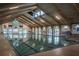 Bright indoor pool with wood beamed ceiling and large windows at 71 Stone Haven Ct, Leesburg, FL 34788