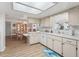 Bright, open kitchen and dining area with white cabinets, modern appliances, and a view to the adjacent dining space at 71 Stone Haven Ct, Leesburg, FL 34788