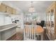 Bright open-concept kitchen and dining area featuring wood floors and a light fixture that complements the dining decor at 71 Stone Haven Ct, Leesburg, FL 34788