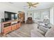 Inviting living room with wood floors, a TV console, and a view into the dining area for easy entertaining and relaxation at 71 Stone Haven Ct, Leesburg, FL 34788