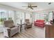 Cozy living room with large windows, wood flooring, and ceiling fan perfect for relaxing or entertaining guests at 71 Stone Haven Ct, Leesburg, FL 34788