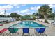Community pool area surrounded by lounge chairs and tropical landscaping at 715 Surrey Pl, Leesburg, FL 34748