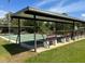 Outdoor shuffleboard court area features shade cover and benches for community recreation and relaxation at 715 Surrey Pl, Leesburg, FL 34748