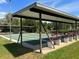 Outdoor shuffleboard court area features shade cover and benches for community recreation and relaxation at 715 Surrey Pl, Leesburg, FL 34748