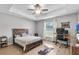 Comfortable bedroom with tray ceiling, ceiling fan, and natural light from the window at 8635 Se 156 St, Summerfield, FL 34491