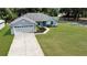 Charming one story home with a well-manicured lawn and a light blue front door at 8635 Se 156 St, Summerfield, FL 34491