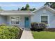 A charming home featuring a vibrant blue front door, flanked by manicured shrubs, and light grey exterior at 8635 Se 156 St, Summerfield, FL 34491