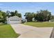 A charming single-Gathering home with a two-car garage, long driveway, and lush front lawn under a blue sky at 8635 Se 156 St, Summerfield, FL 34491