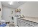 Well-lit laundry room boasts a granite countertop, sink, and modern washer and dryer units at 8635 Se 156 St, Summerfield, FL 34491