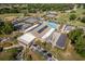 Aerial view of the community clubhouse, golf course, tennis courts, swimming pool, and solar panels at 8738 Sw 95Th Ln # B, Ocala, FL 34481