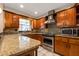 Well-lit kitchen featuring granite countertops, stainless steel appliances, and wood cabinetry at 8738 Sw 95Th Ln # B, Ocala, FL 34481
