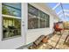 Back exterior featuring a door, windows, potted plants, outdoor furniture and a screened lanai at 8932 Se 168Th Sedgwick Pl, The Villages, FL 32162