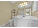 Bathroom with white sink vanity, mirror, a rack, toilet, and tile flooring at 8932 Se 168Th Sedgwick Pl, The Villages, FL 32162