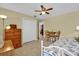 Cozy bedroom with tile flooring, ceiling fan and comfortable furnishings offering a serene personal space at 8932 Se 168Th Sedgwick Pl, The Villages, FL 32162