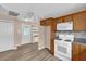 Cozy kitchen featuring wood cabinets, granite countertops, and white appliances, offering a blend of warmth and functionality at 8932 Se 168Th Sedgwick Pl, The Villages, FL 32162