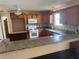 Well-lit kitchen features wooden cabinets, backsplash, granite countertops, and updated appliances at 8932 Se 168Th Sedgwick Pl, The Villages, FL 32162