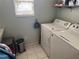 Functional laundry room equipped with washer, dryer, and storage shelves for organized convenience at 8932 Se 168Th Sedgwick Pl, The Villages, FL 32162