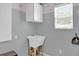 Practical laundry area featuring a utility sink and storage, providing convenience for laundry needs at 8932 Se 168Th Sedgwick Pl, The Villages, FL 32162