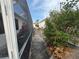 Side yard featuring a paved walkway and a screen porch alongside some decorative shrubbery at 8932 Se 168Th Sedgwick Pl, The Villages, FL 32162