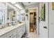 Bright bathroom featuring a white vanity, decorative mirror, and an organized linen closet at 1 Aberdeen Cir, Leesburg, FL 34788