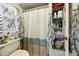Neat bathroom with patterned shower curtain, a toilet, and convenient built-in shelving at 1 Aberdeen Cir, Leesburg, FL 34788