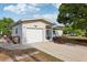 View of the home's exterior showing the garage, walkway, and neutral color scheme at 1 Aberdeen Cir, Leesburg, FL 34788