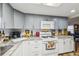 This kitchen features granite countertops, white appliances and gray cabinetry at 1 Aberdeen Cir, Leesburg, FL 34788